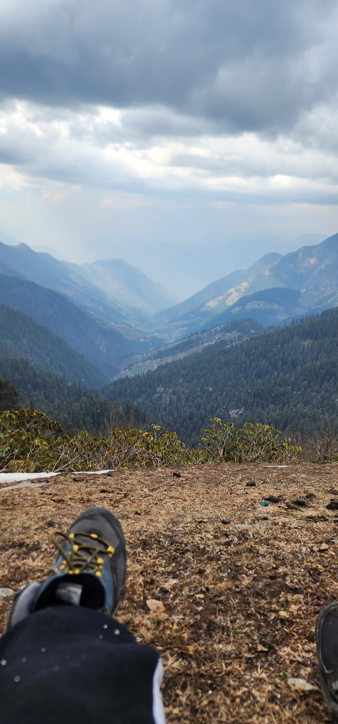 View of rolling green mountains and forested valleys under a cloudy sky