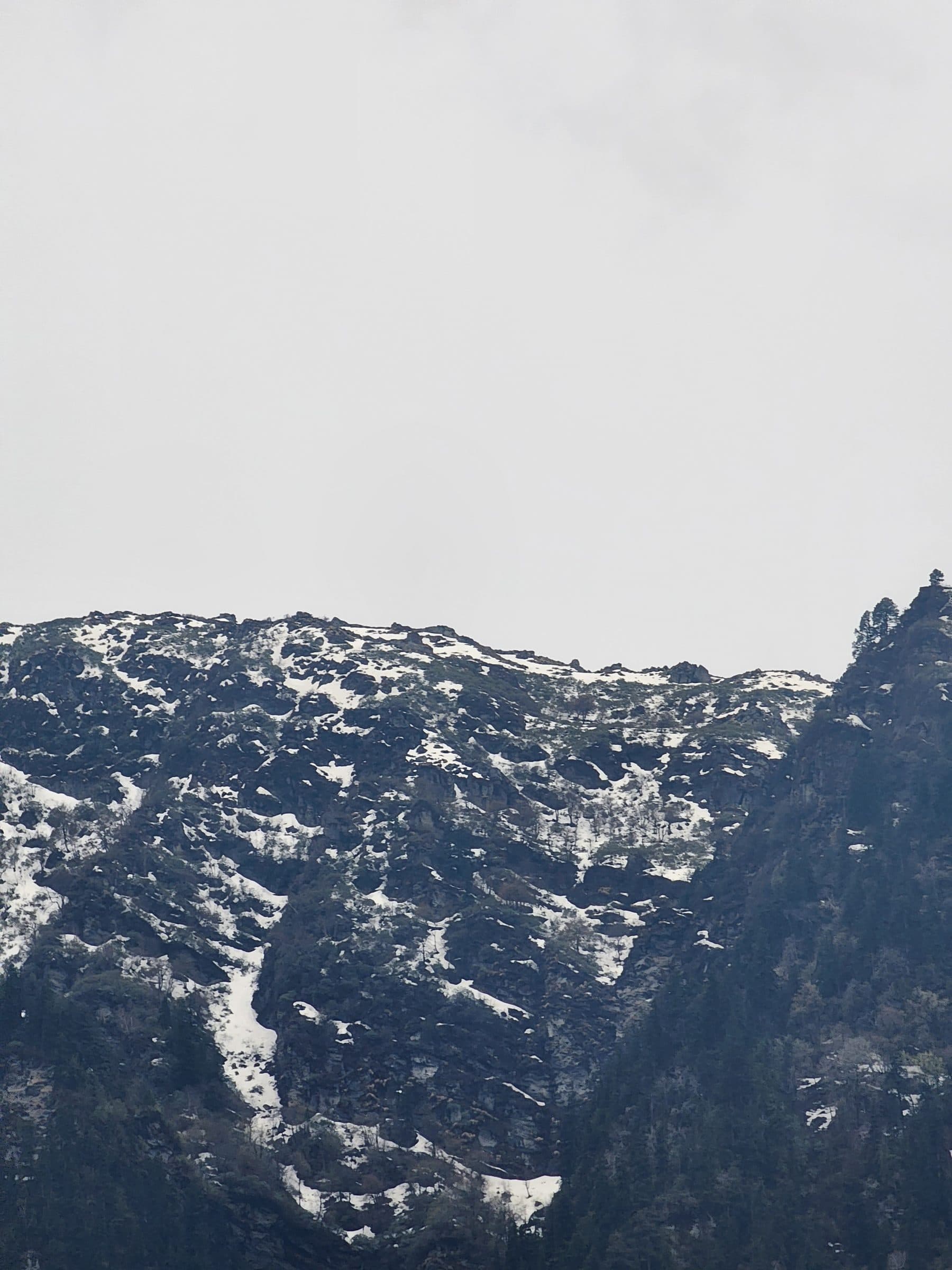 Vast landscape of snow-covered mountains under an overcast sky