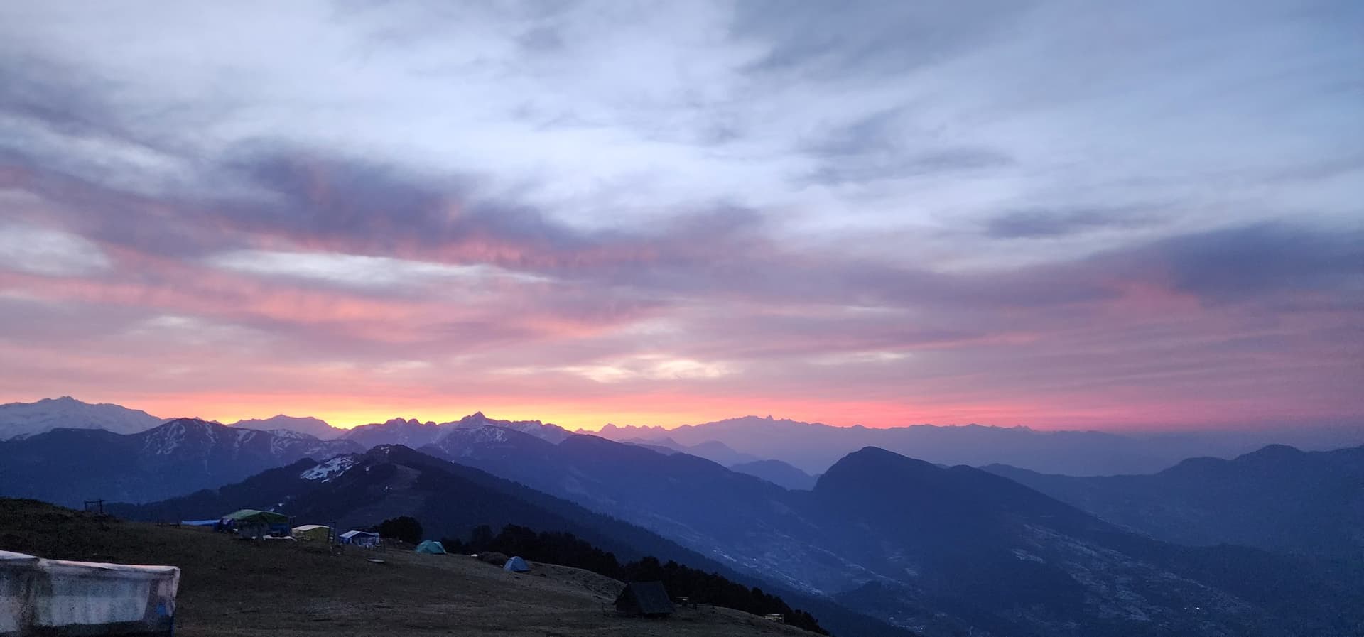 Vast mountain range landscape with pink and purple hues during sunrise or sunset