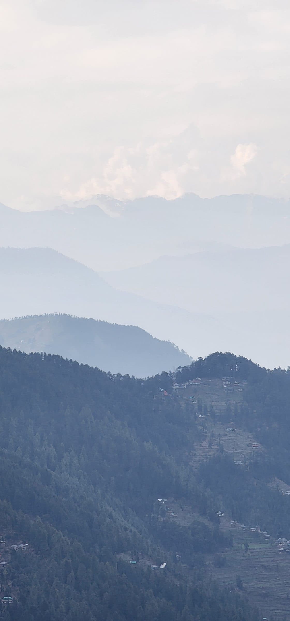 Layered, misty mountains and dense forests in the Jibhi Valley landscape