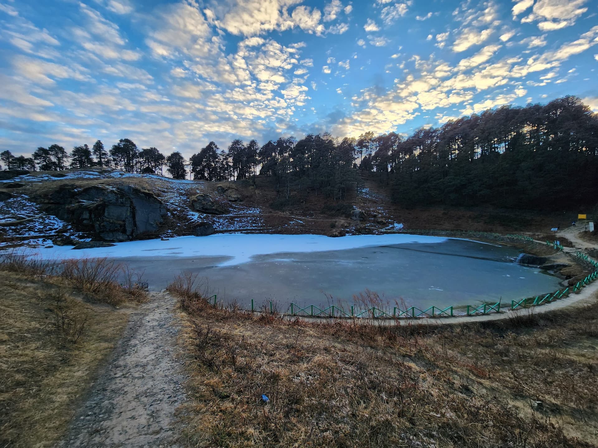 Serolsar Lake bordered by dense pine trees