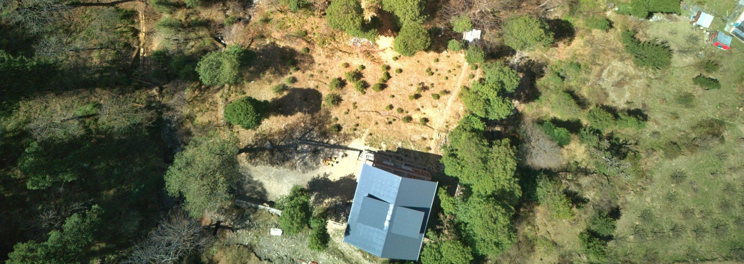 Ailyak Shoja - Nesteled within forest with a stream nearby