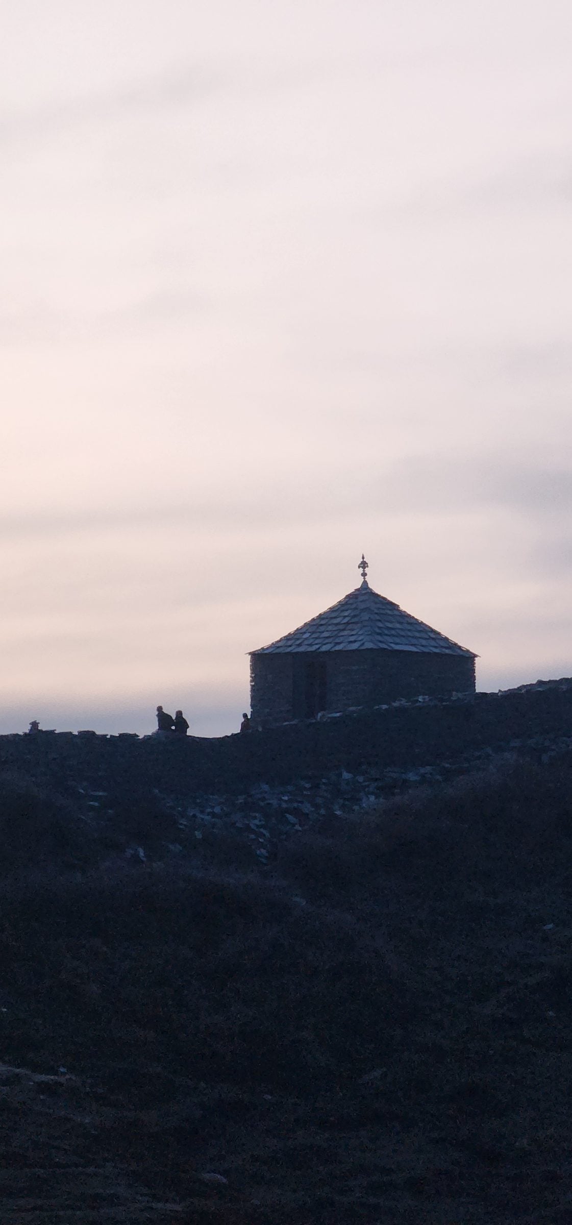 Silent Silhouette of Jibhi Valley, Himachal Pradesh A solitary stone structure sits in the dark valley of Jibhi, Himachal Pradesh, India, under a vast evening sky.