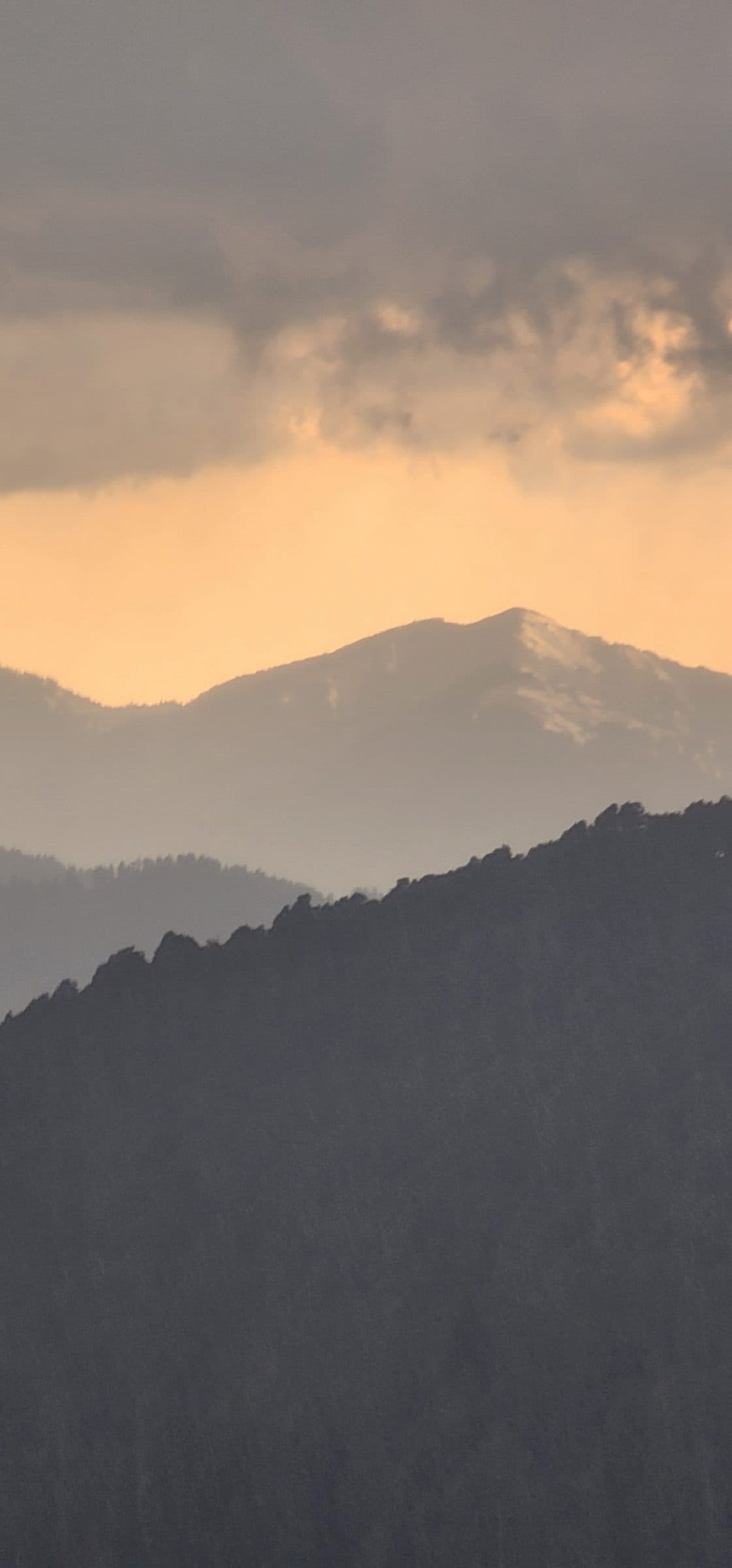 A stunning panoramic view of Shoja village in the Jibhi Valley, Himachal Pradesh, India, bathed in warm golden light.