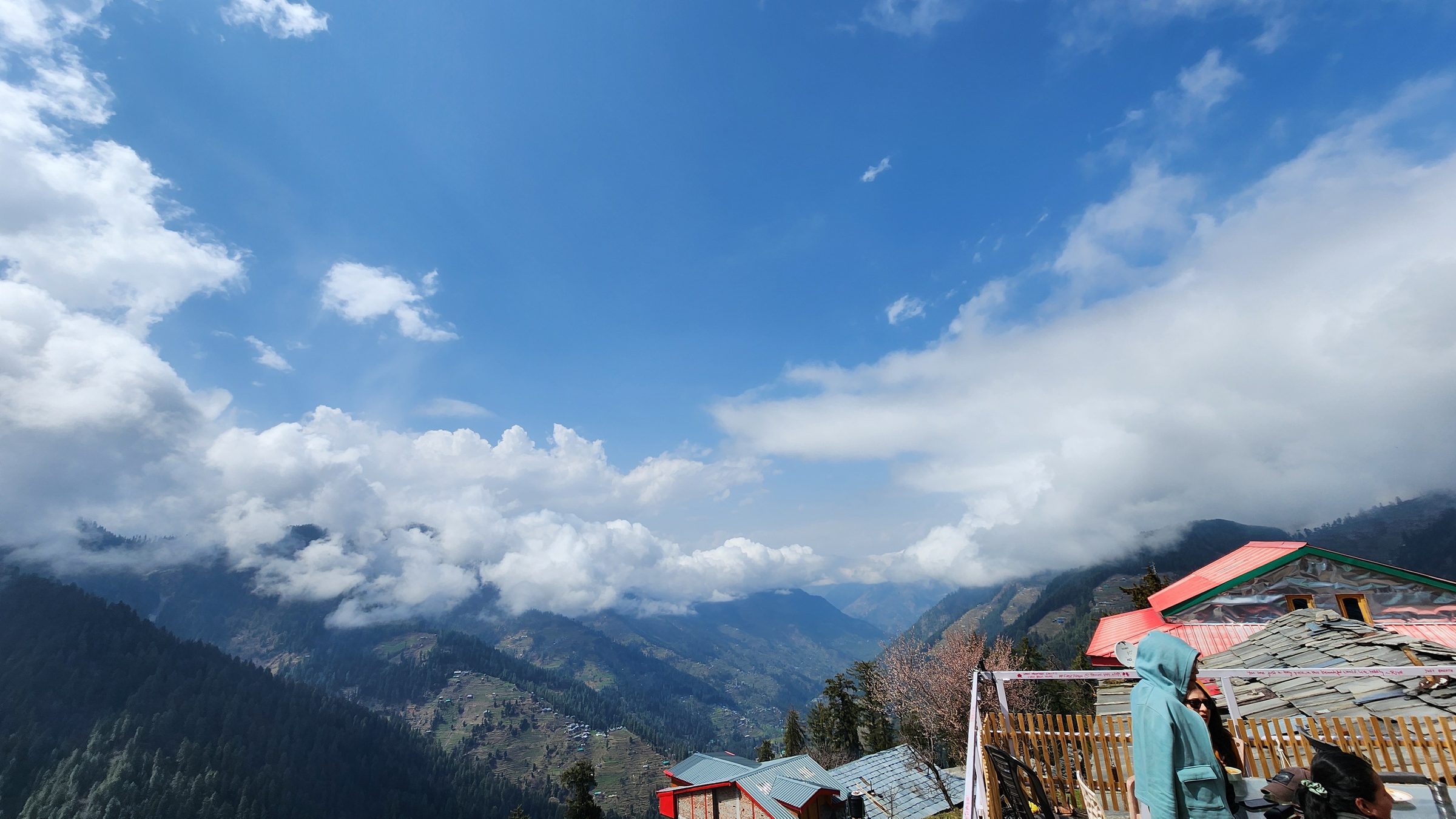 Mountain landscape and blue sky with white clouds above small buildings